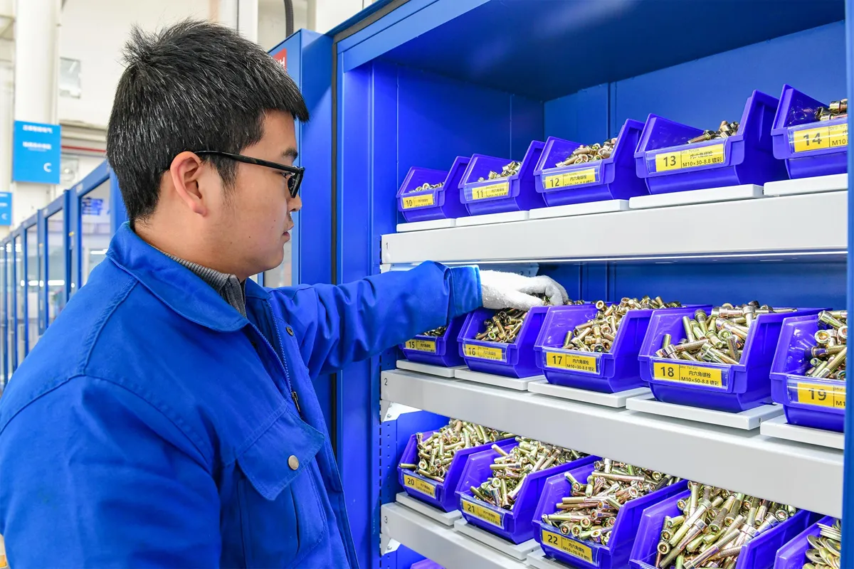 Een gebruiker neemt onderdelen uit een materiaalbak in een SmartWeight-kast